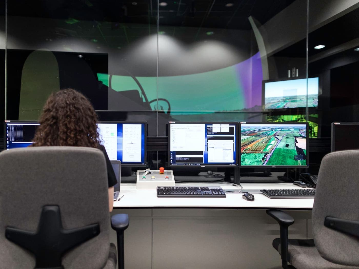 An operator at a control room desk with several screens